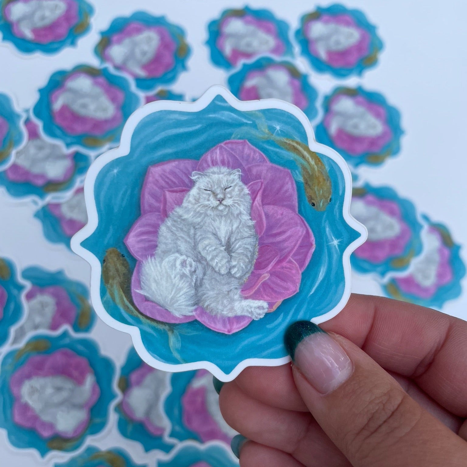 Sticker of a cat on a pink flower held by a hand with a patterned background